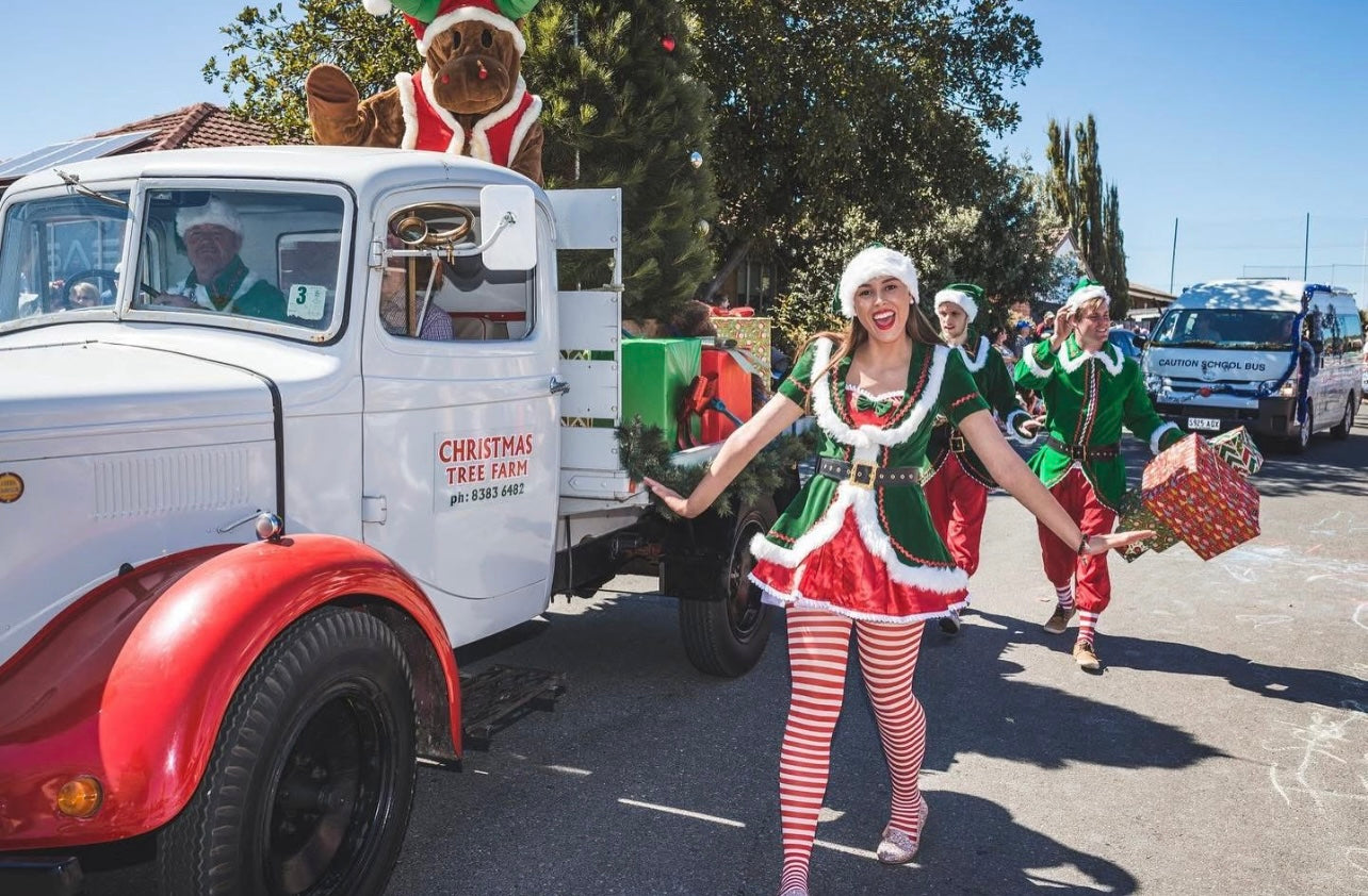 Photo of Chandlers Hill Christmas Tree Farm staff taking part in a Christmas pageant with the farm’s delivery truck, showcasing festive holiday spirit, community involvement, and family-friendly Christmas activities