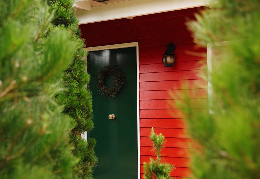 Close-up of Santa’s cottage nestled in the forest with lush green Christmas trees at Chandlers Hill Christmas Tree Farm